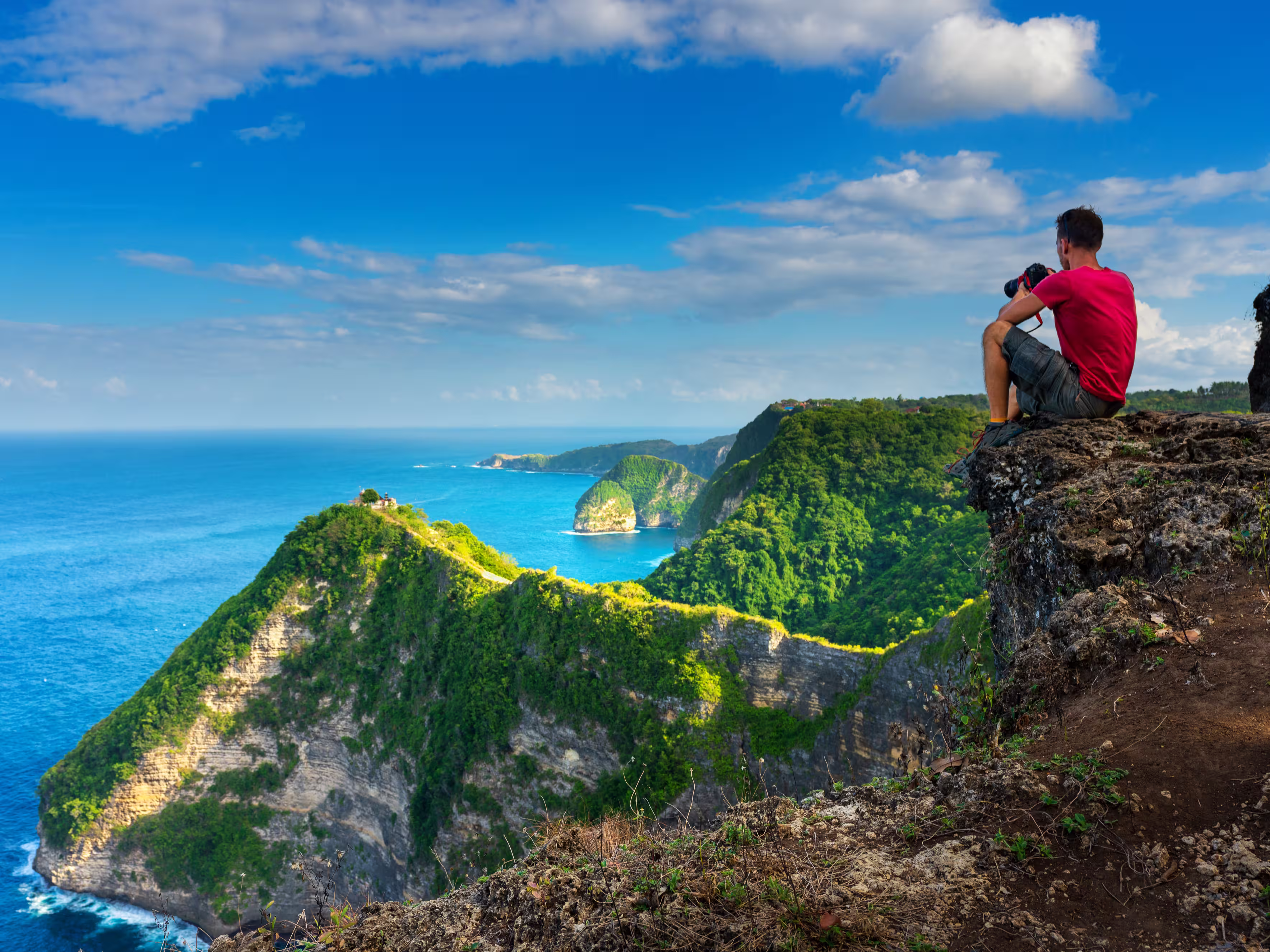 Traveler look at the ocean and rocks. Travel and active life concept. Adventure and travel on Bali, Indonesia.