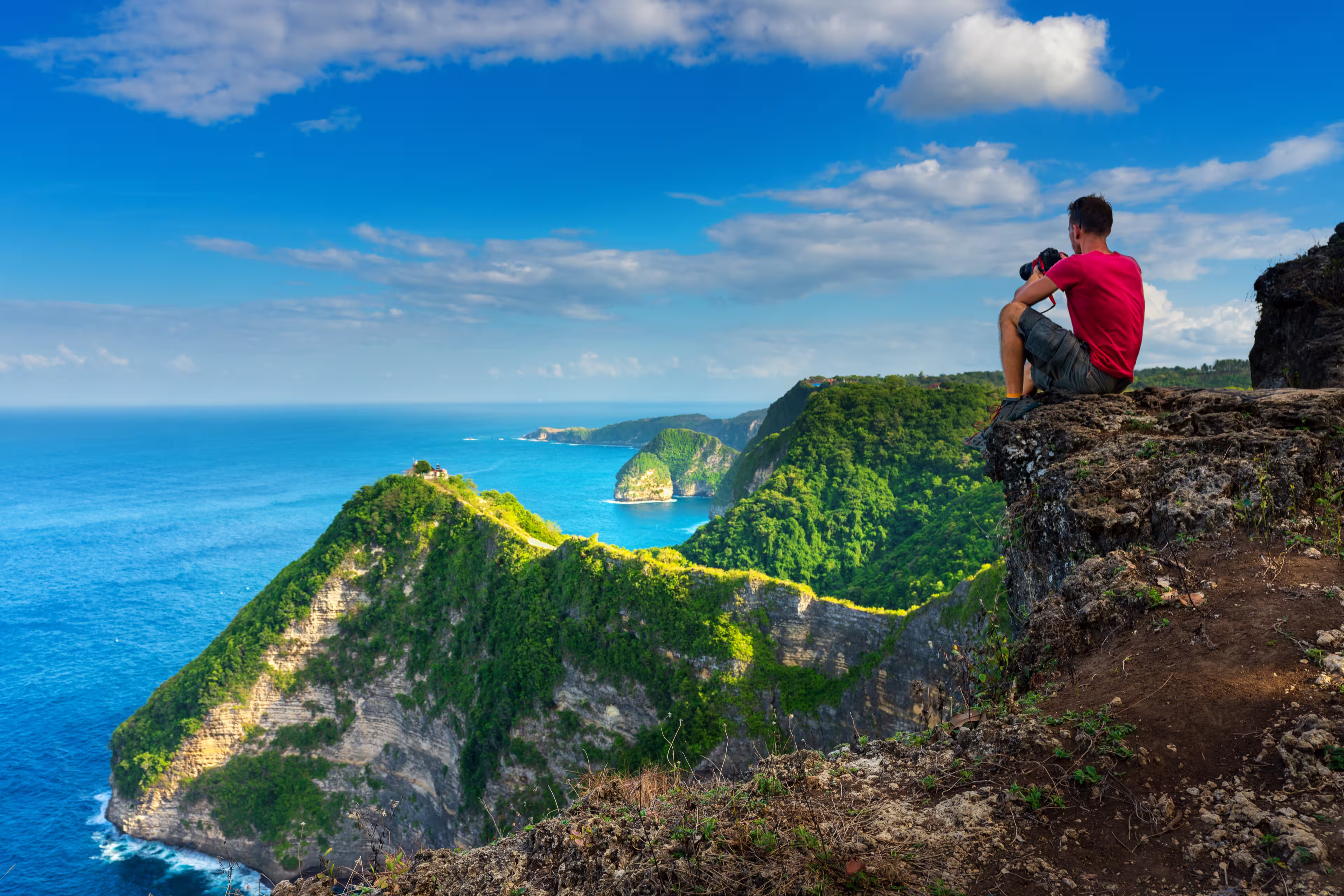 Traveler look at the ocean and rocks. Travel and active life concept. Adventure and travel on Bali, Indonesia.