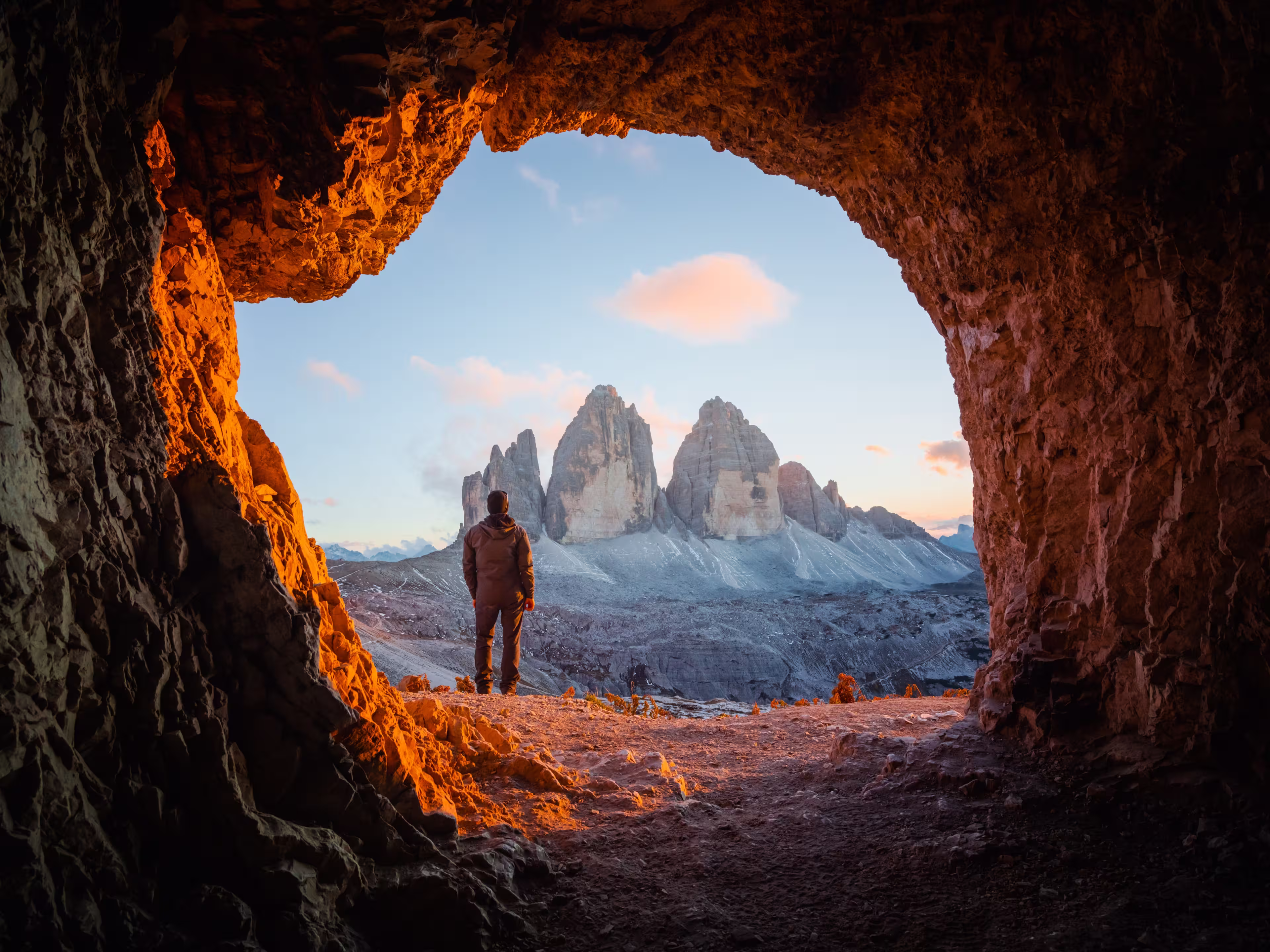 Tre Cime Di Lavaredo peaks in incredible orange sunset light. View from the cave in mountain against Three peaks of Lavaredo, Dolomite Alps, Italy, Europe. Landscape photography