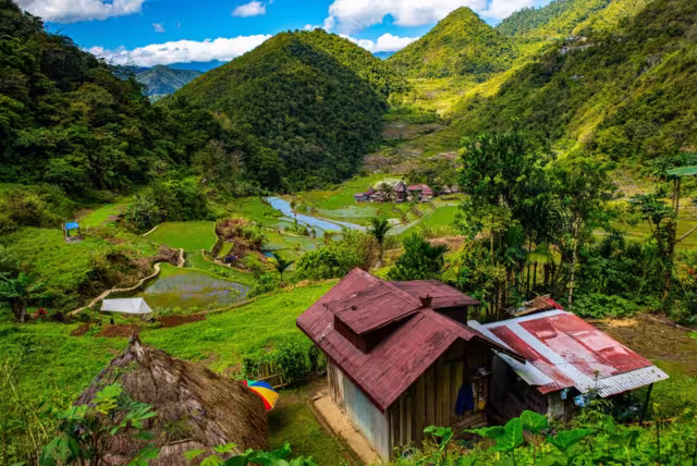 Iron sheet rooved homes of Bangaan village in foreground and distance in the midst of layered rice terraces