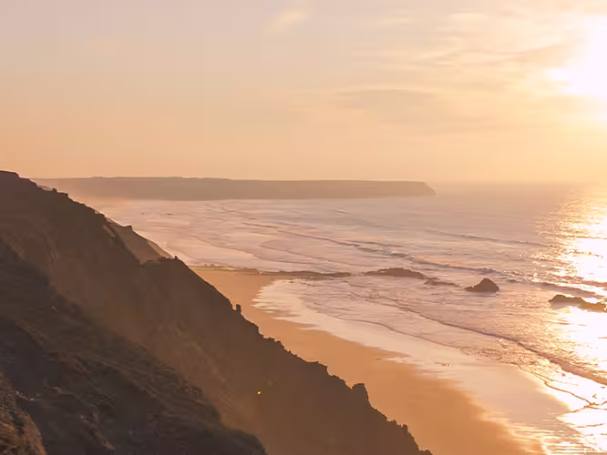 Traveller hiking along coastline of Rota Vicentina at sunset, Portgual