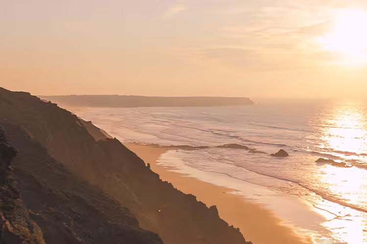 Traveller hiking along coastline of Rota Vicentina at sunset, Portgual