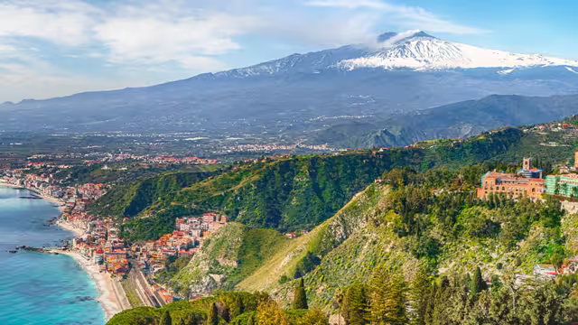 View of the town Taormini on the Sicilian coast with Mt. Etna in the background, Italy