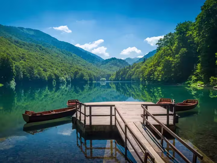 Panoramic view of Biogradsko lake. Virgin forests and beautiful mountains, wooden pier and boats. National park Biogradska gora is very popular touristic destination in Montenegro.