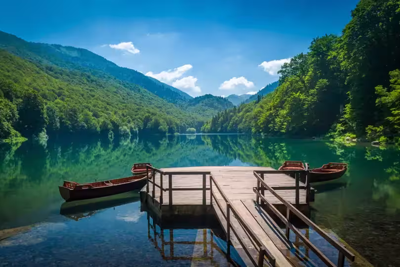 Panoramic view of Biogradsko lake. Virgin forests and beautiful mountains, wooden pier and boats. National park Biogradska gora is very popular touristic destination in Montenegro.