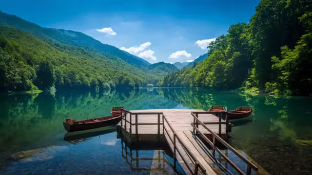 Panoramic view of Biogradsko lake. Virgin forests and beautiful mountains, wooden pier and boats. National park Biogradska gora is very popular touristic destination in Montenegro.