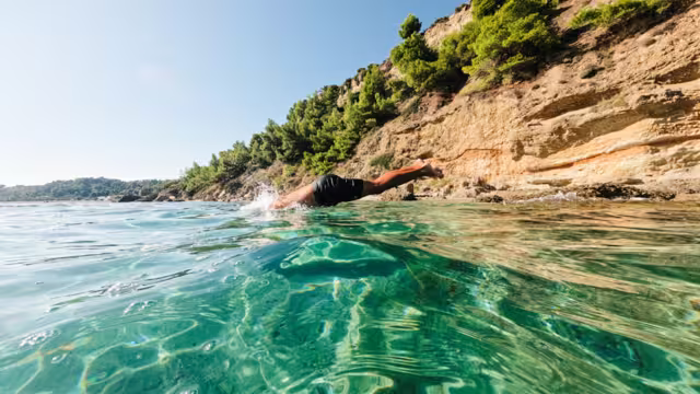 Intrepid traveller dives off submerged rock into the Aegean Sea off the coast of Alonnisos in the Sporades archipelago in Greece