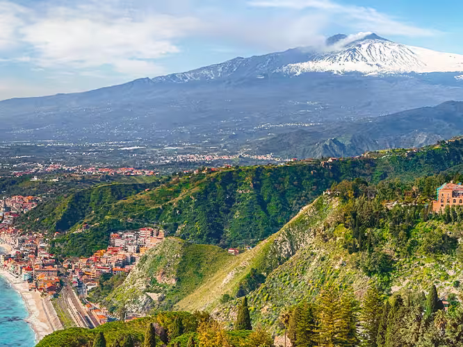View of the town Taormini on the Sicilian coast with Mt. Etna in the background, Italy