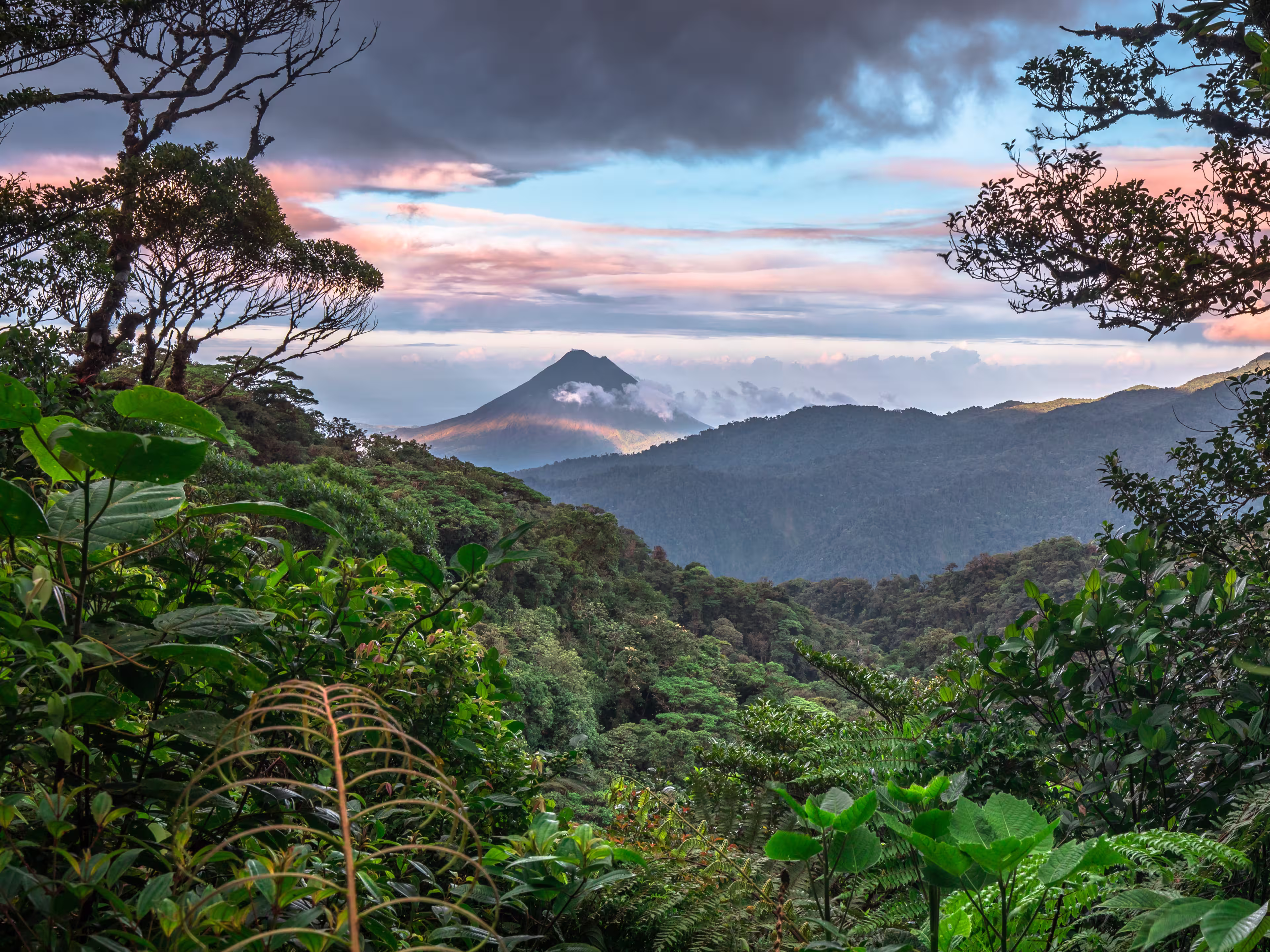 Volcan Arenal dominates the landscape during sunset, as seen from the Monteverde area, Costa Rica.