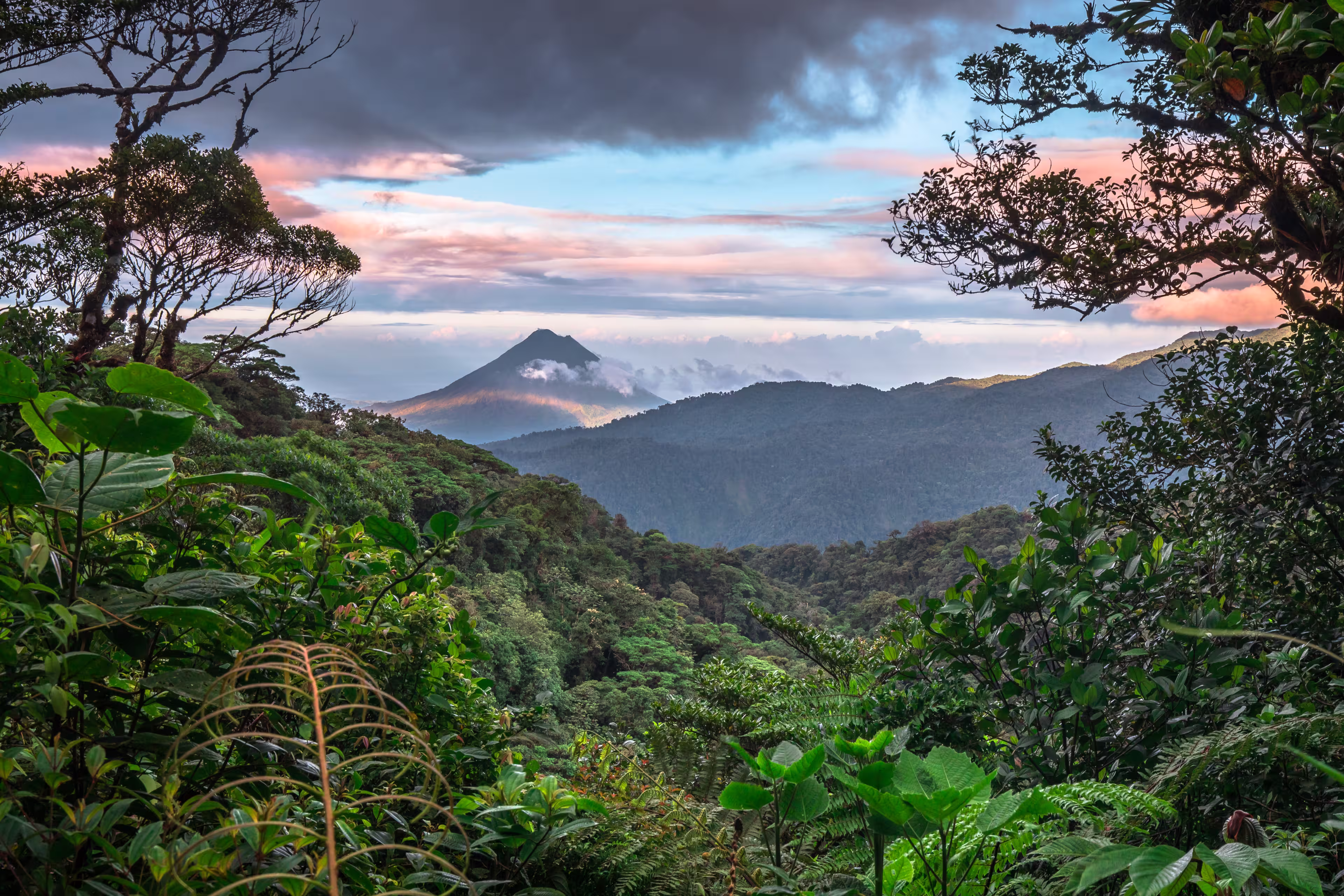 Volcan Arenal dominates the landscape during sunset, as seen from the Monteverde area, Costa Rica.