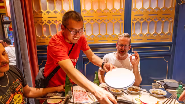 Intrepid leader stirs a sichuan hotpot for a traveller in Chengdu China
