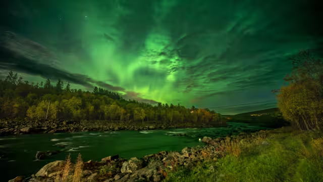 Northern lights over Neiden in the Sør-Varanger, Northeast Norway, with vibrant aurora colors illuminating the Arctic night sky.