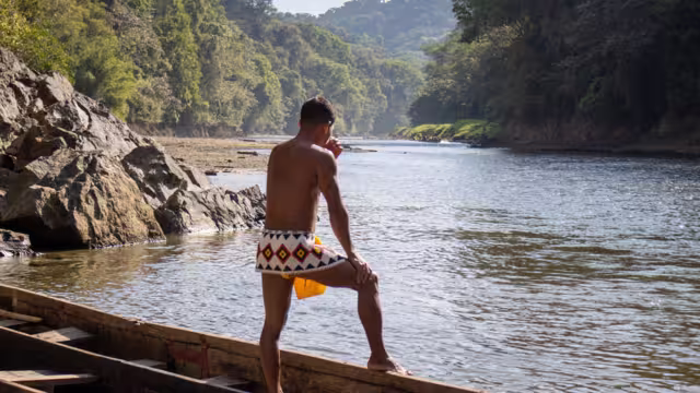 Member of the Emberá Indigenous people contemplates the Chagres River in the midst of Panama's rainforest
