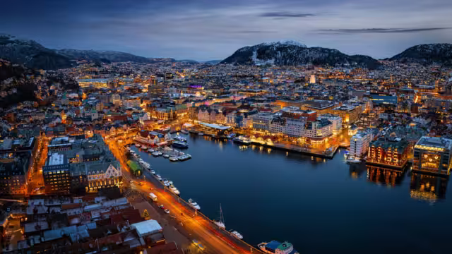 Panoramic aerial view of the illuminated cityscape of Bergen, Norway, during a cold winter night