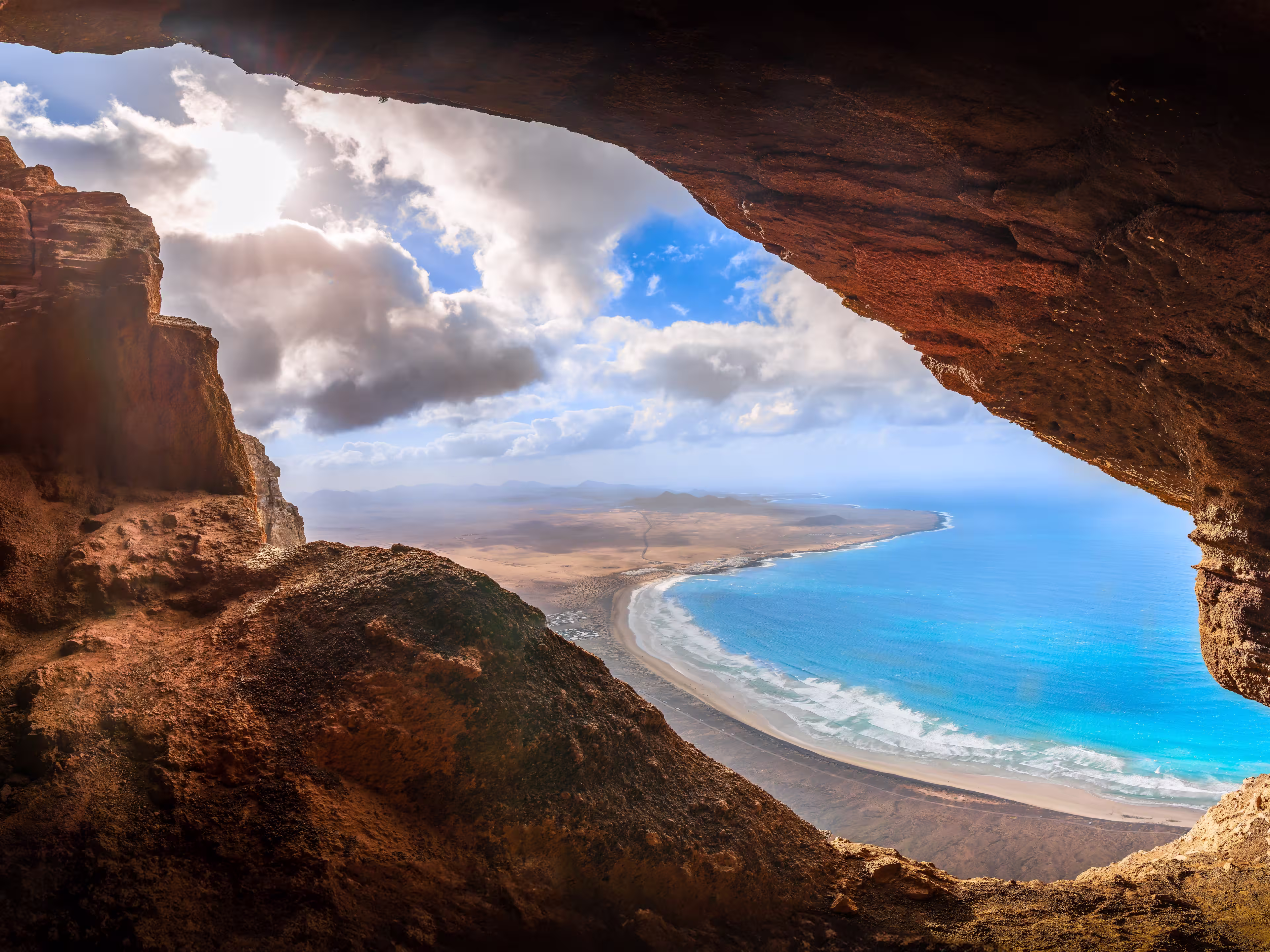 Unveil the beauty of Cueva De Los Suecos in Haría, Lanzarote, where majestic cliffs frame the serene Atlantic, a perfect fusion of geology and artistry.