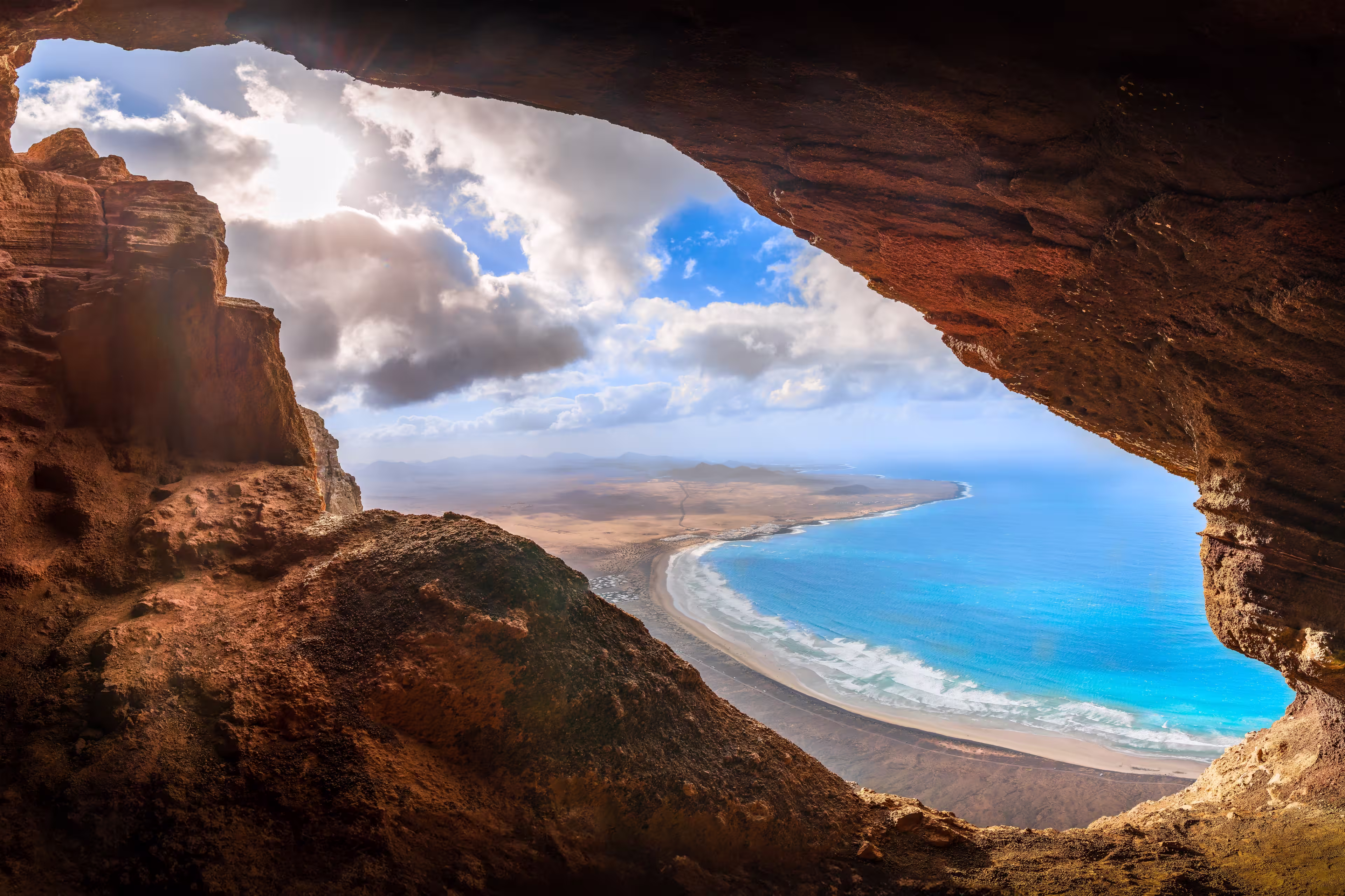 Unveil the beauty of Cueva De Los Suecos in Haría, Lanzarote, where majestic cliffs frame the serene Atlantic, a perfect fusion of geology and artistry.