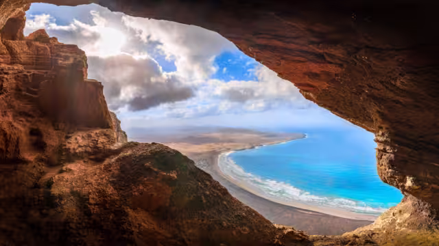 Unveil the beauty of Cueva De Los Suecos in Haría, Lanzarote, where majestic cliffs frame the serene Atlantic, a perfect fusion of geology and artistry.