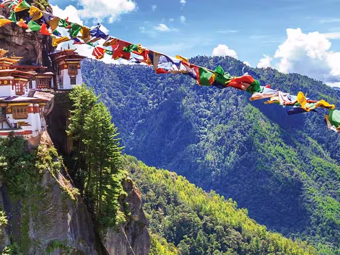 HEPIC - View of the Tiger Monastery and colourful flags on a hill in Bhutan