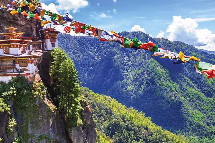 HEPIC - View of the Tiger Monastery and colourful flags on a hill in Bhutan
