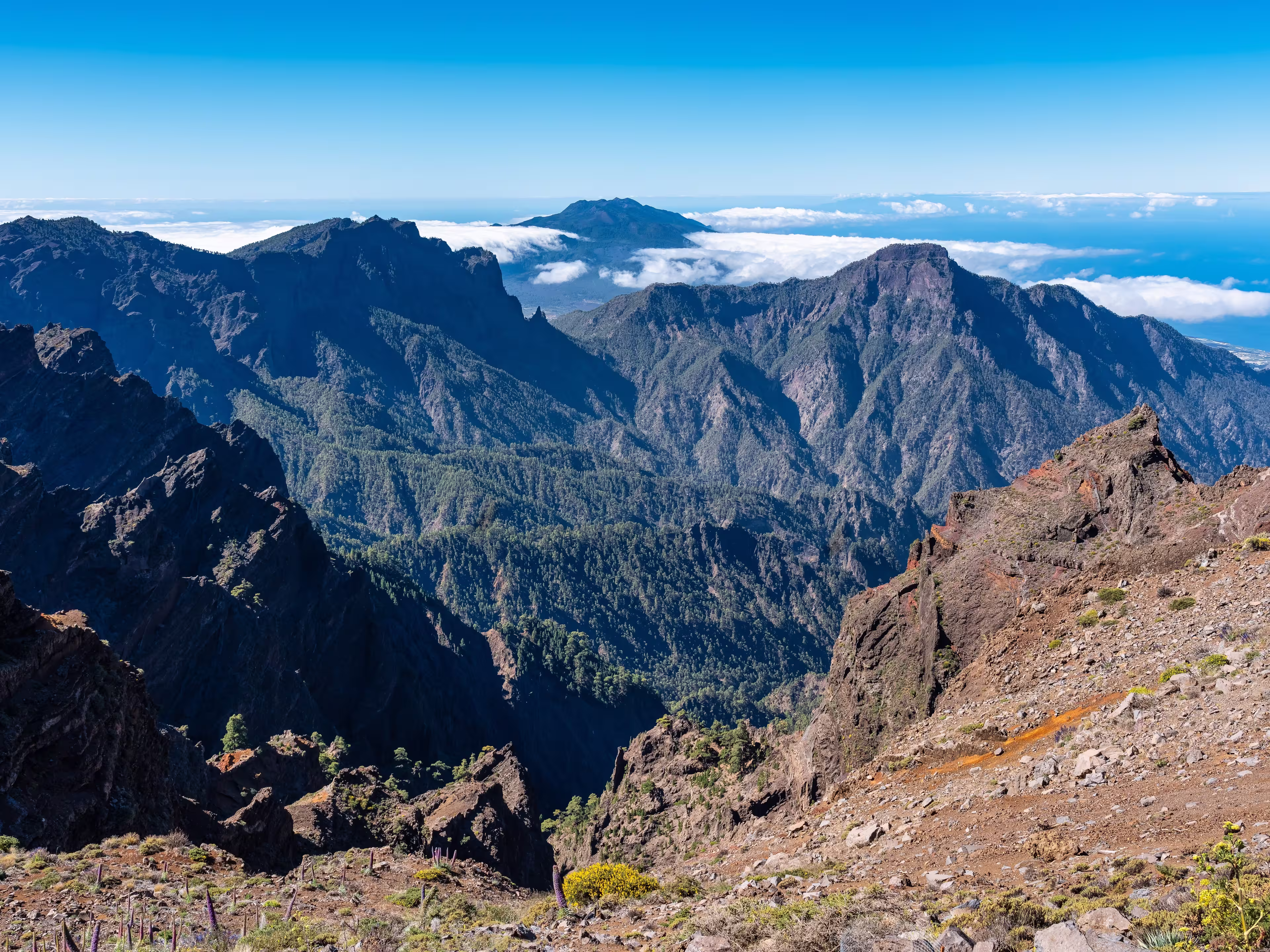 Impressive mountain range of volcanic rock with a volcano emerging from the clouds, La Palma, Canary Islands.