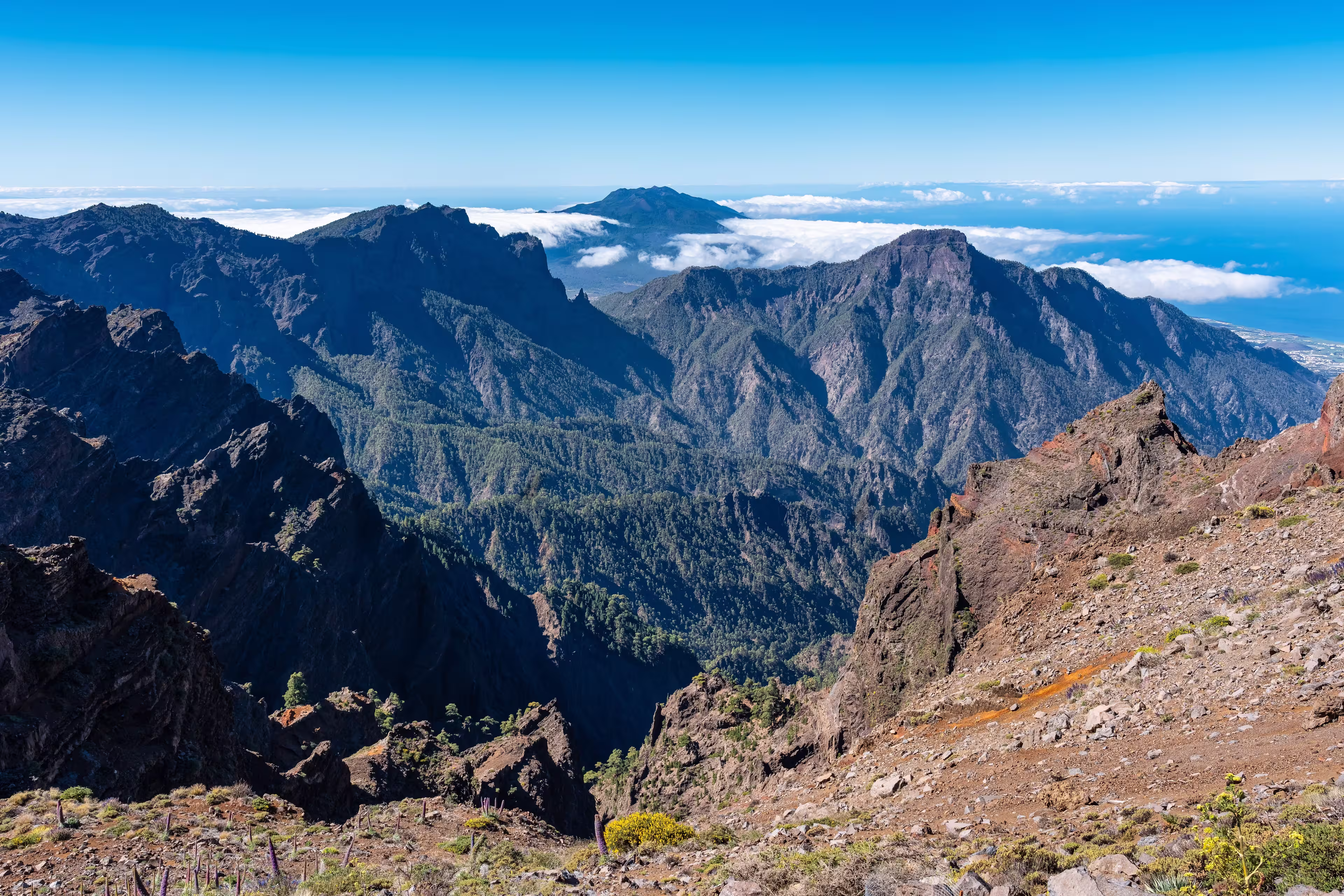 Impressive mountain range of volcanic rock with a volcano emerging from the clouds, La Palma, Canary Islands.