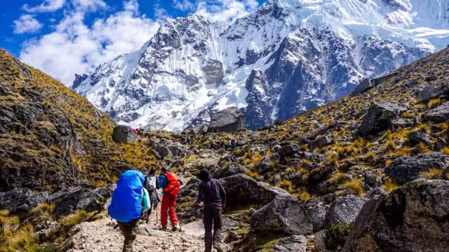 Travellers trekking towards snowcapped mountain Salkantay insight, along the Andes ranges in Peru