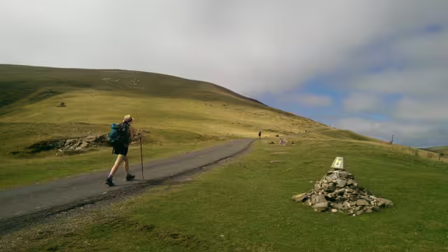 Pilgrims walking in the mountains of the Pyrenees, on the border between France and Spain. Roncesvalles. Pilgrimage of Compostela, Camino de santiago.