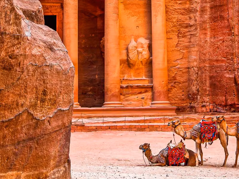 View of camels resting in front of the Treasury, known locally as Al Khazneh, as seen from the main entrance to the ancient city, known locally as Al-Siq, located in the UNESCO World Heritage Site of Petra, or Rose-Red city, which was the 6th century capital city of the Nabataeans.