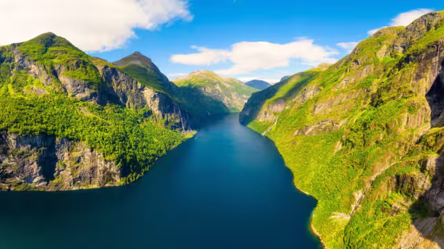 Geiranger Fjord, Norway. Nature in fjords. Traveling by boat on a Norwegian fjord. Scandinavia. View of nature from the drone. Seven Sisters Waterfall. Vacation and travel in summer Norway.