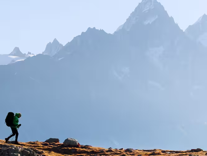 Hiker trekking with Mont Blanc mountain range in the background