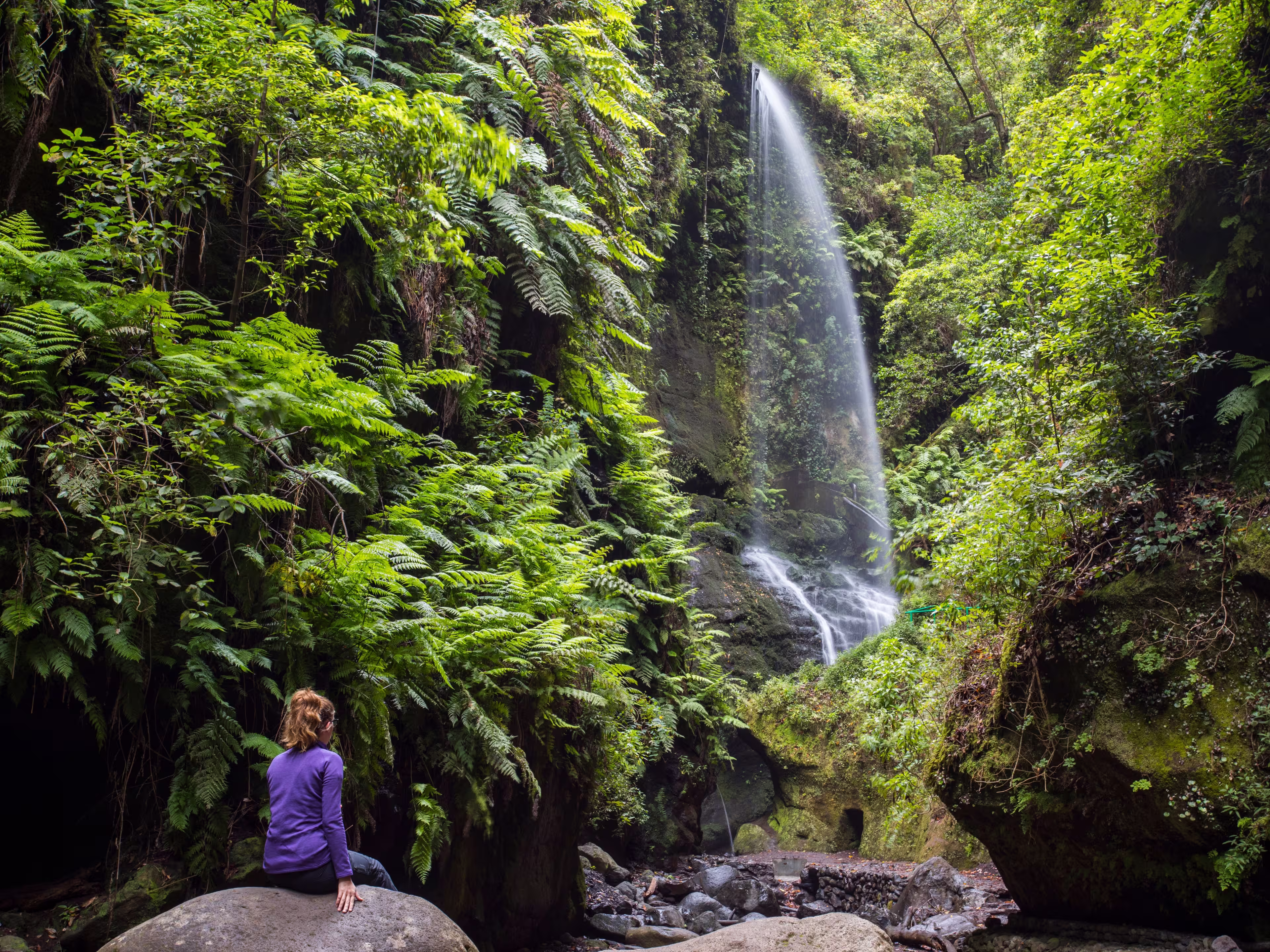 A young woman in Tilos waterfall, La Palma Island, Canary Islands, Spain.