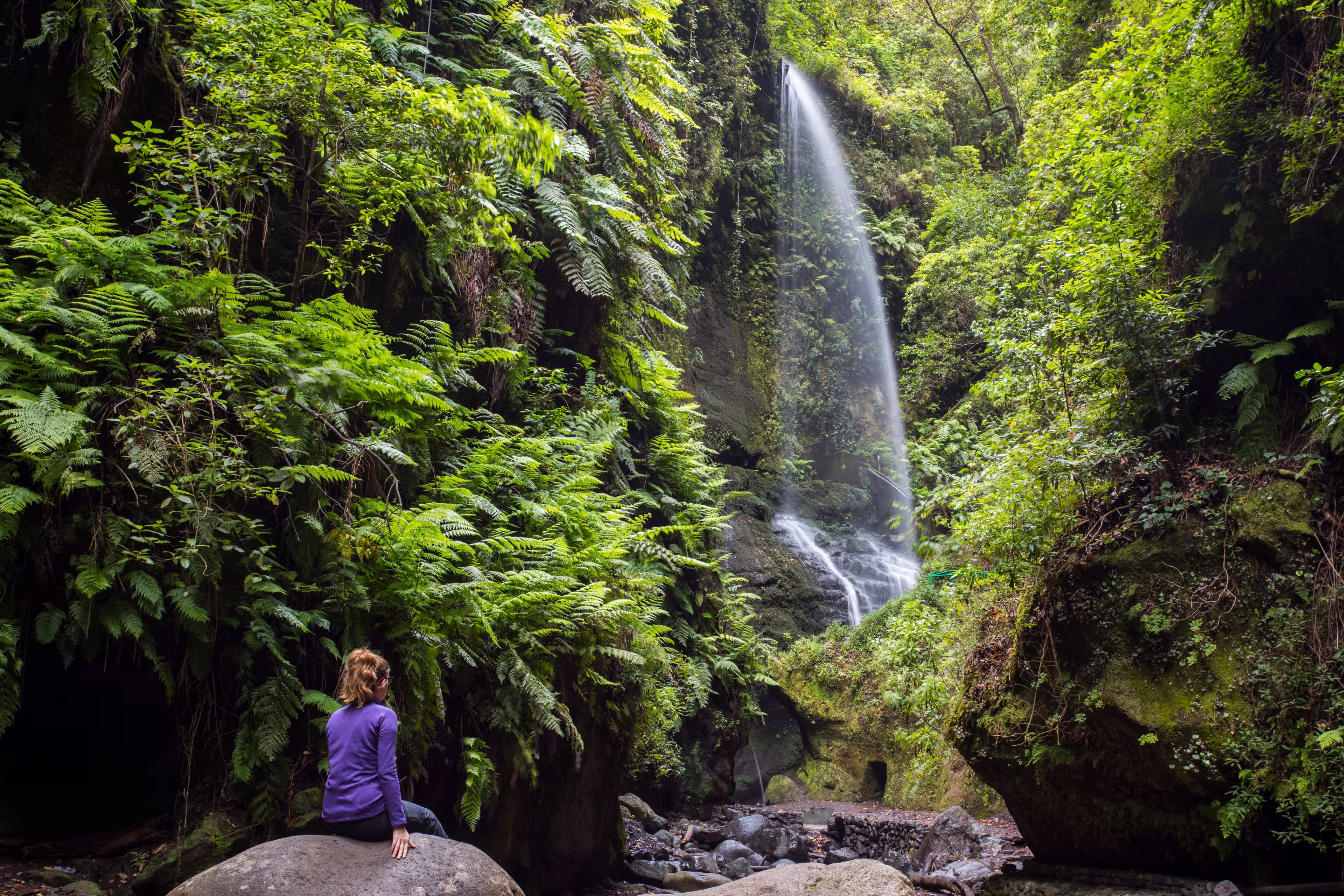 A young woman in Tilos waterfall, La Palma Island, Canary Islands, Spain.