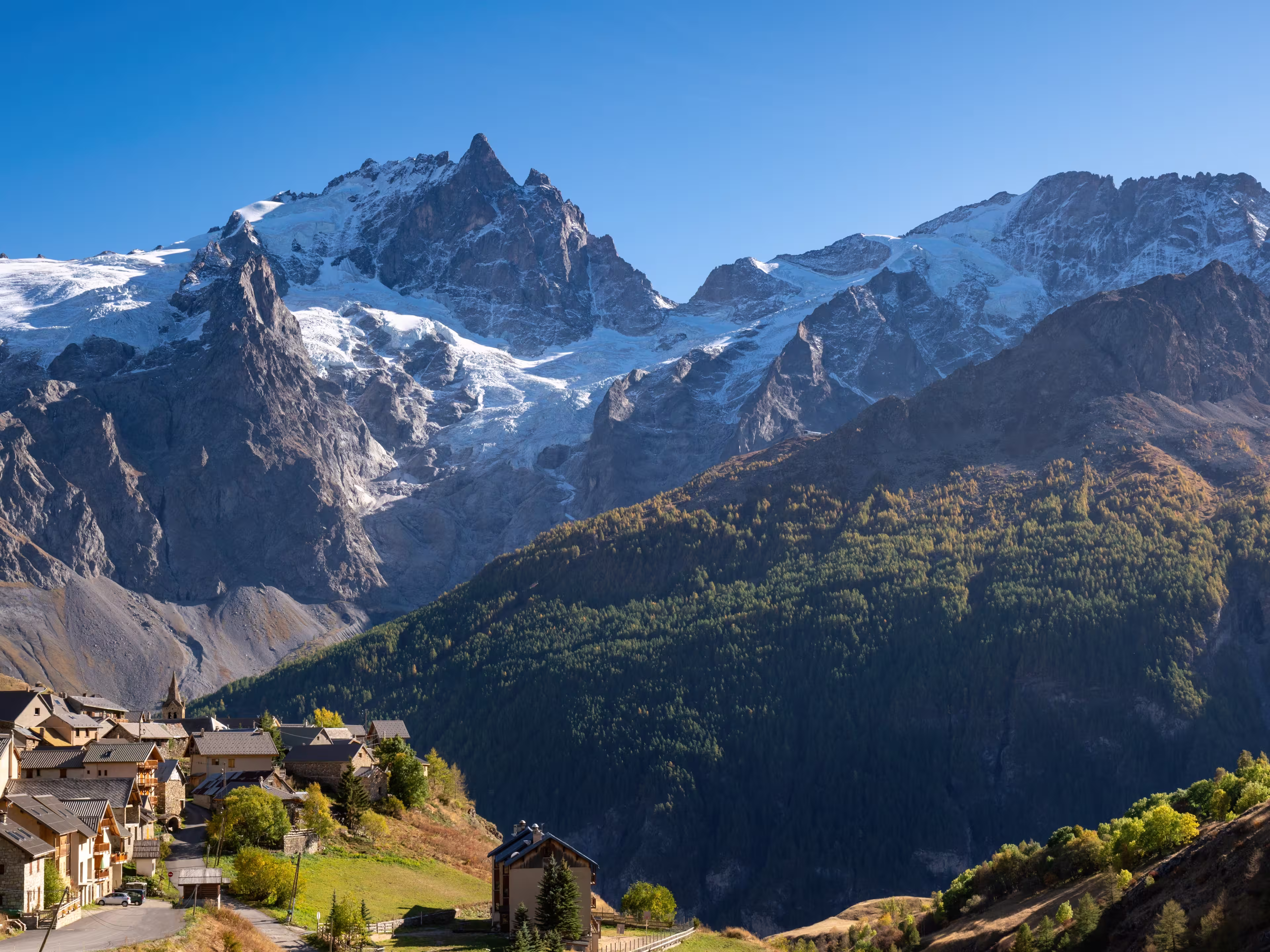 La Meije peak in Ecrins National Park with the village of Le Chazelet and glacier in Autumn. Hautes-Alpes, French Alps, France