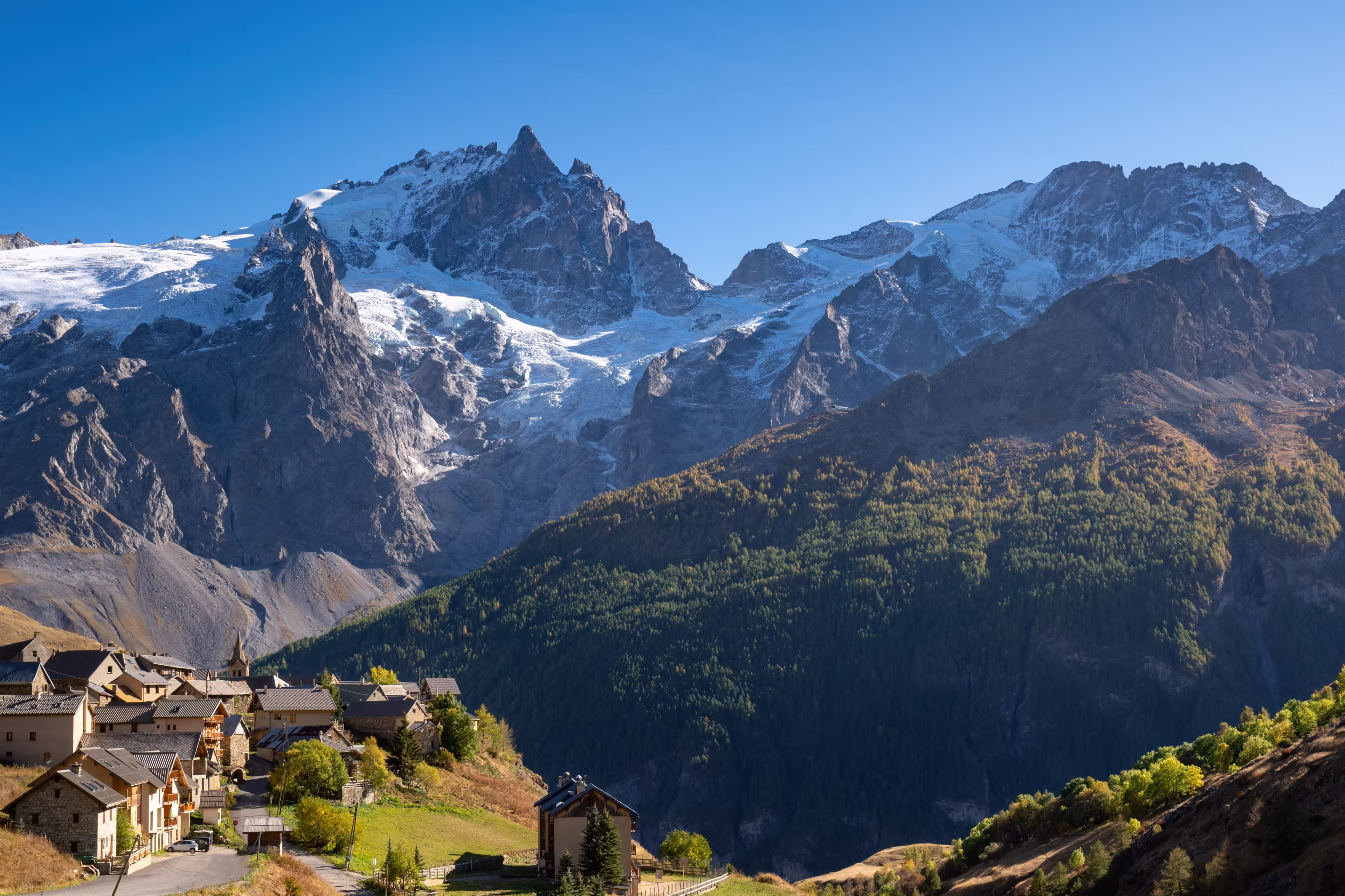La Meije peak in Ecrins National Park with the village of Le Chazelet and glacier in Autumn. Hautes-Alpes, French Alps, France