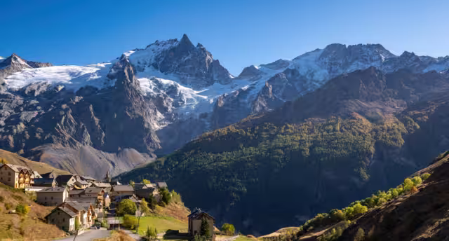La Meije peak in Ecrins National Park with the village of Le Chazelet and glacier in Autumn. Hautes-Alpes, French Alps, France