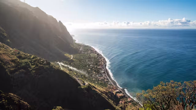 Panoramic view of Paul do Mar and the coast of Madeira near Fãja da Ovelha, seen from a Miradouro viewpoint at the "Vereda dos Zimbreiros" hiking trail