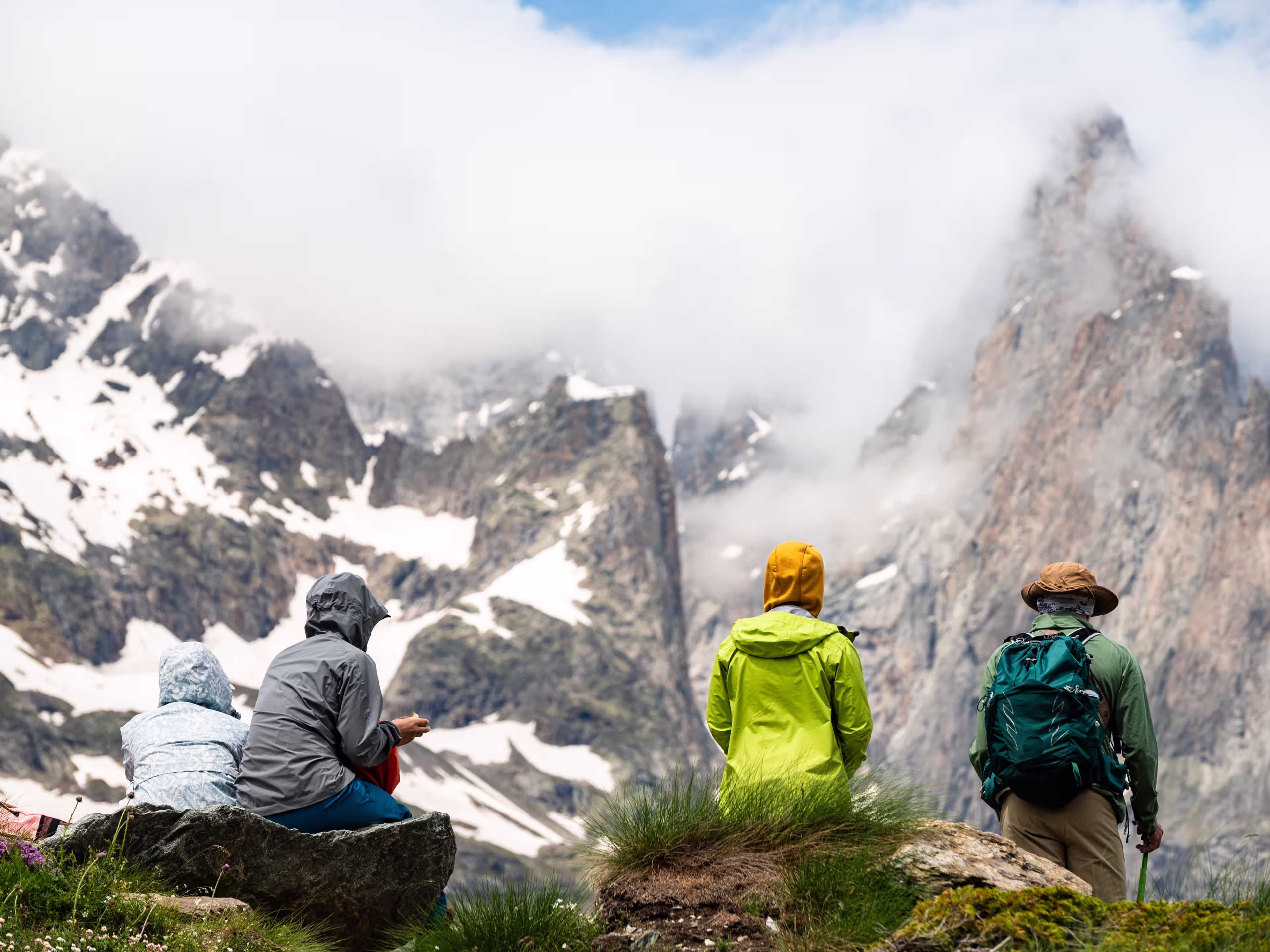 A group of tourists look at the panorama of a glacier in the Mont Blanc massif, the Alps during the famous hike - Tour du Mont Blanc