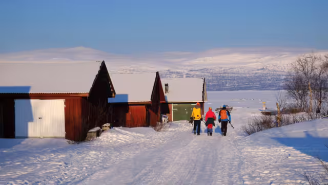 Group of tourists in Abisko is going to Lake Torneträsk (Tornestrask) in winter scenery. Abisko National Park (Abisko nationalpark), Sweden, Arctic Circle, Swedish Lapland