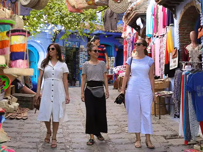 Travellers walking through colourful markets in Chefchaouen, Morocco