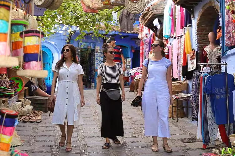 Travellers walking through colourful markets in Chefchaouen, Morocco