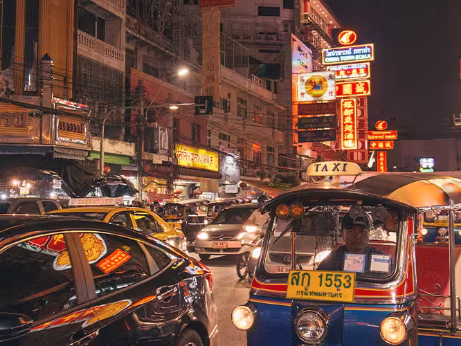 Street view of the hustle and bustle of Bangkok lit up at night