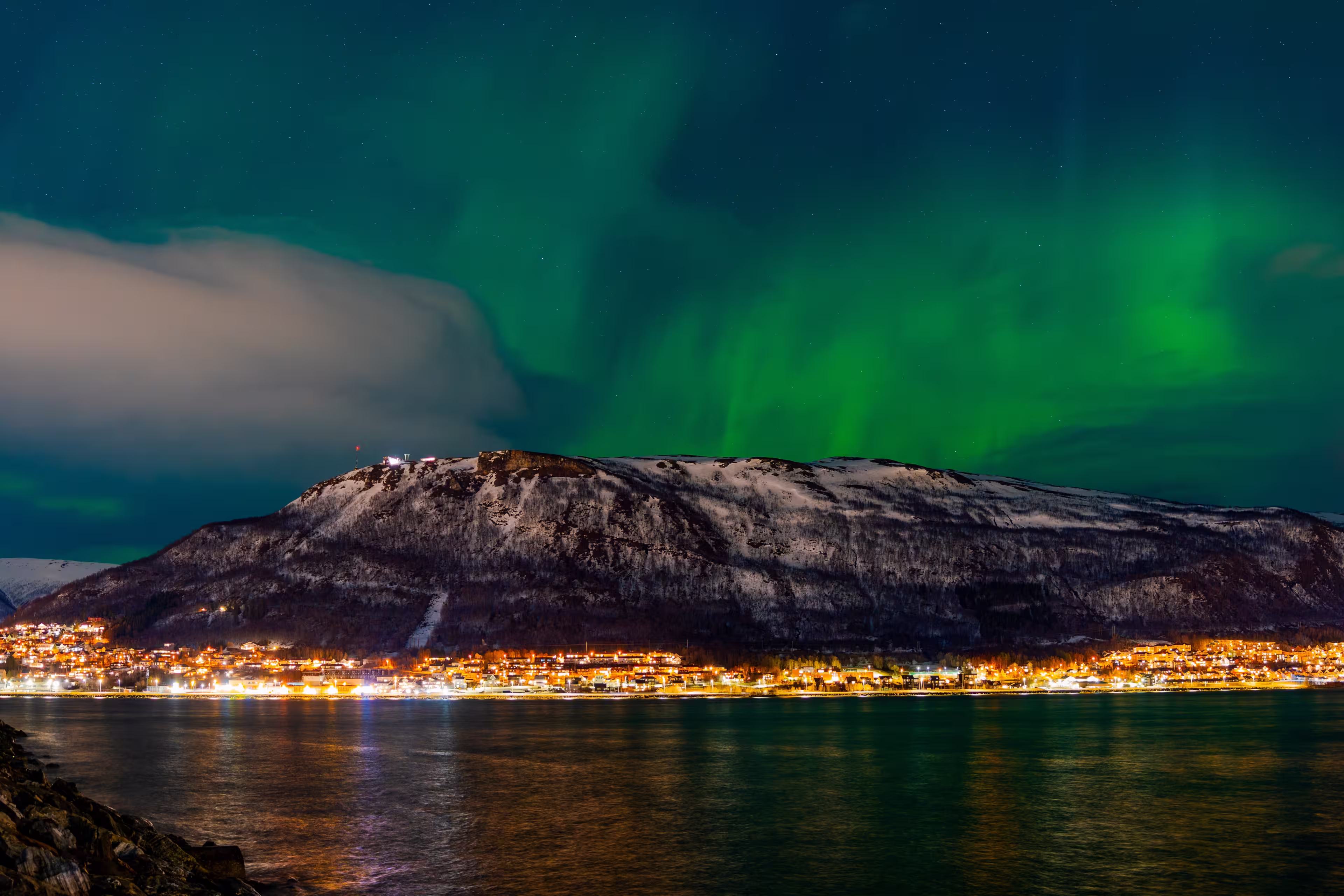 Tromsø, Troms, Norway - 28 February 2025 - Glimpse of Tromsø with the sky lit up by the Northern Lights