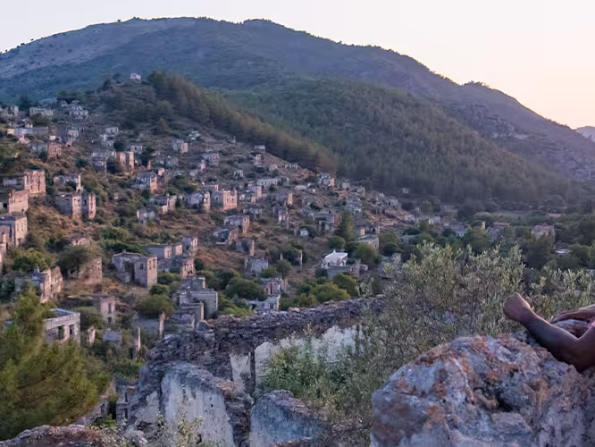 Group of travellers watching sunset in Kayakoy village, Turkey