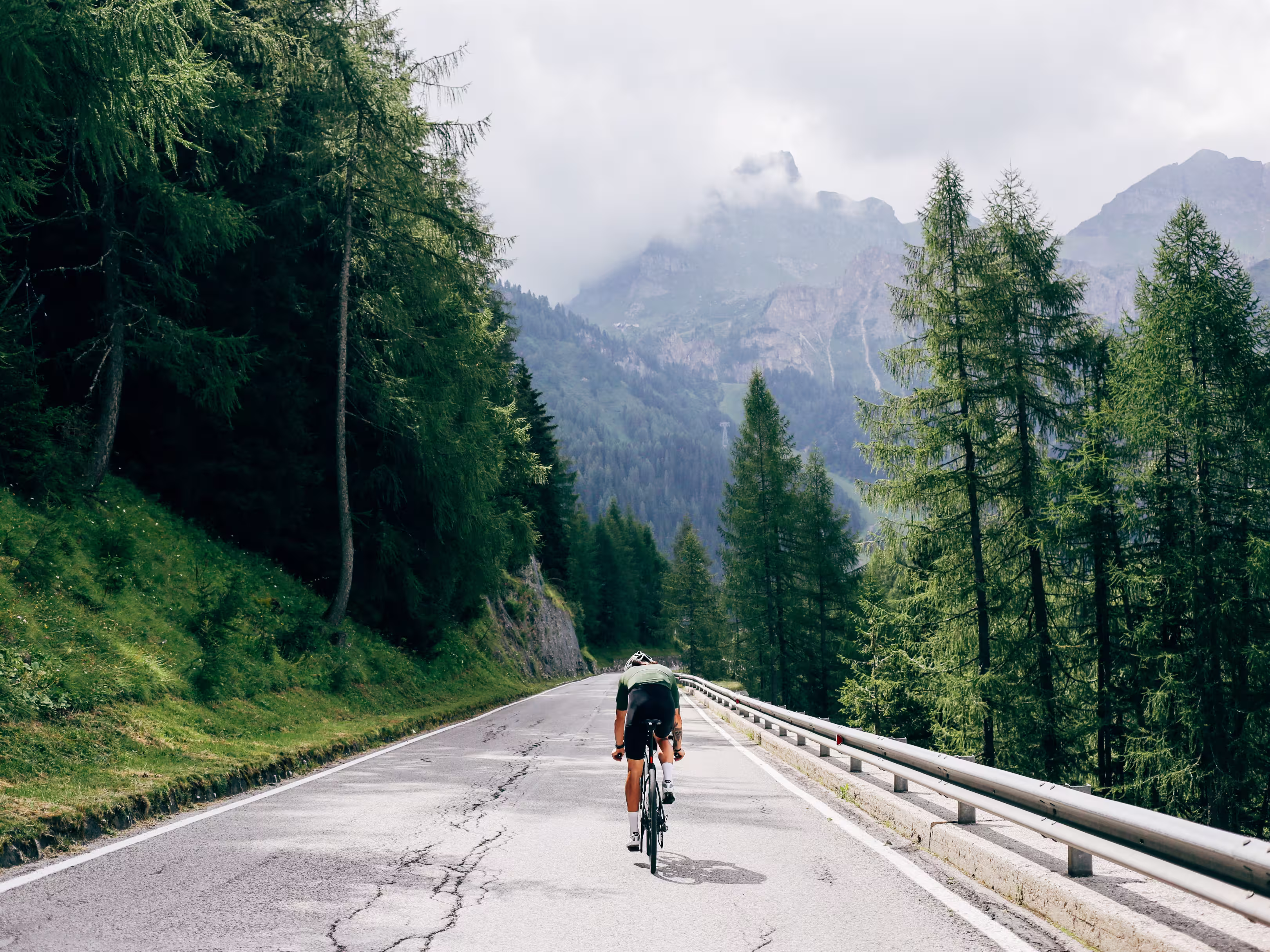 Professioneller Radfahrer mit schnellem und leichtem Kohlenstoff-Fahrrad steigt in den Alpen-Dolomiten auf die Bergstraße ab.