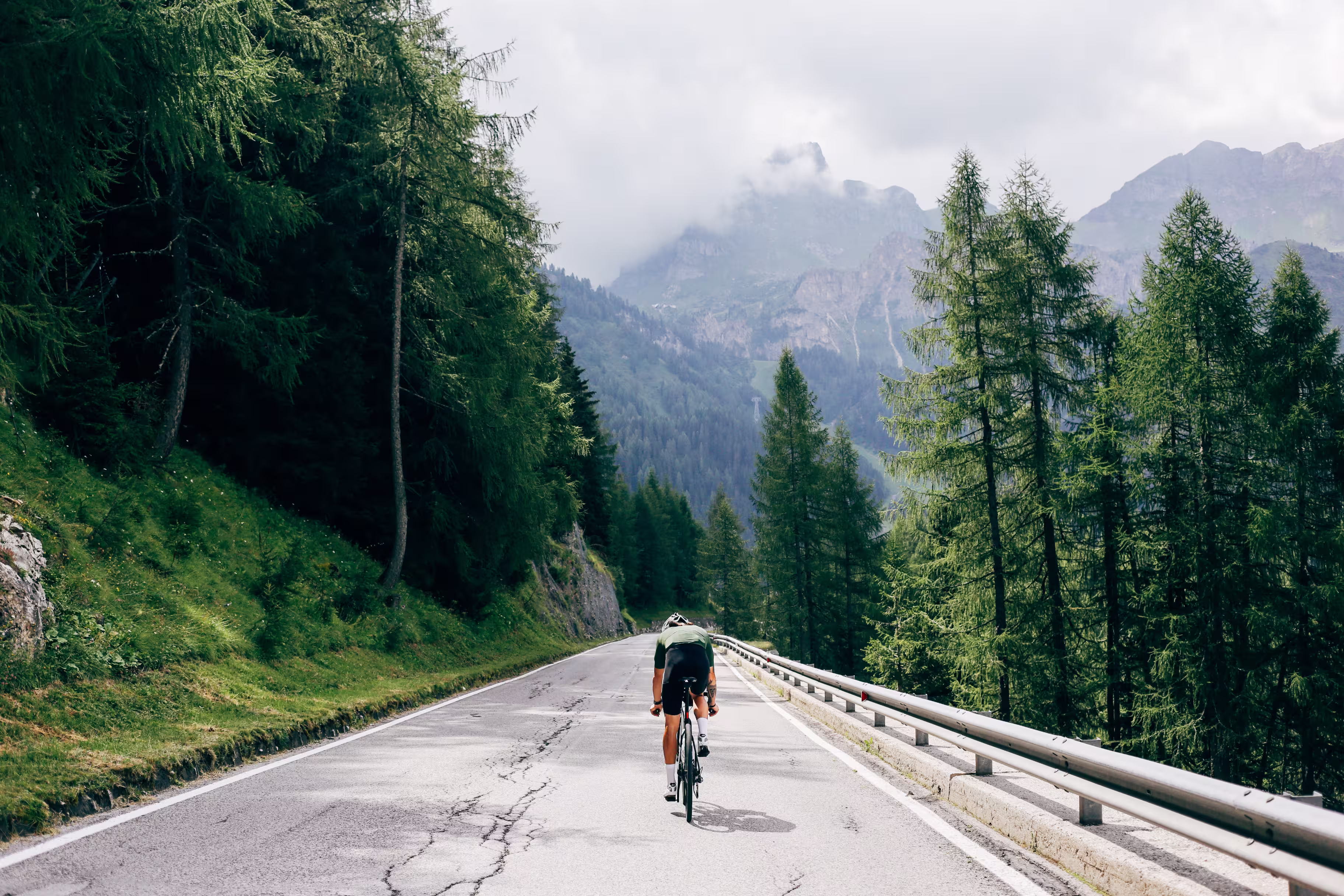 Professioneller Radfahrer mit schnellem und leichtem Kohlenstoff-Fahrrad steigt in den Alpen-Dolomiten auf die Bergstraße ab.