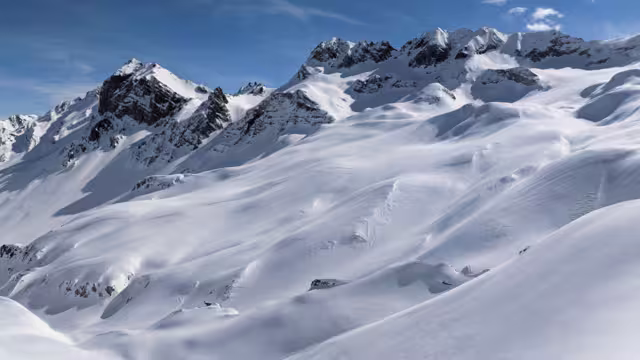 Panorama of the climber on the snow capped mountain range. Ducan Glacier in Switzerland. Freeride in the mountains