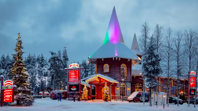 EUROPE, FINLAND, ROVANIEMI, DECEMBER 30, 2017 - Snow-covered buildings in Santa Park against the backdrop of the midnight sun. Rovaniemi, Finland.