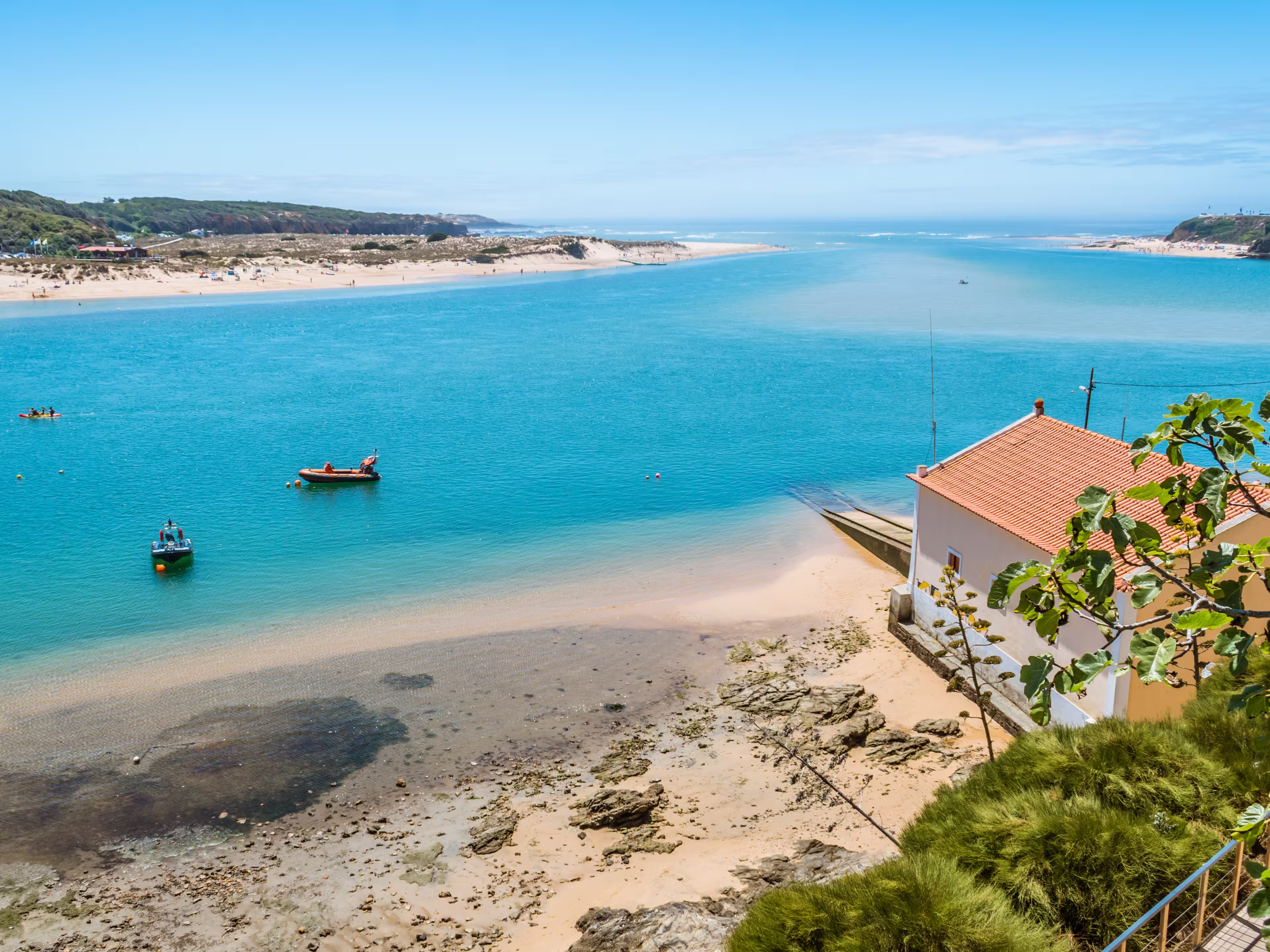 Breathtaking view of the mouth of the River Mira flowing into the Atlantic Ocean - Aquatic lifestyle sport in idyllic turquoise water, Vila Nova de Milfontes, Vicentine Coast Natural Park PORTUGAL