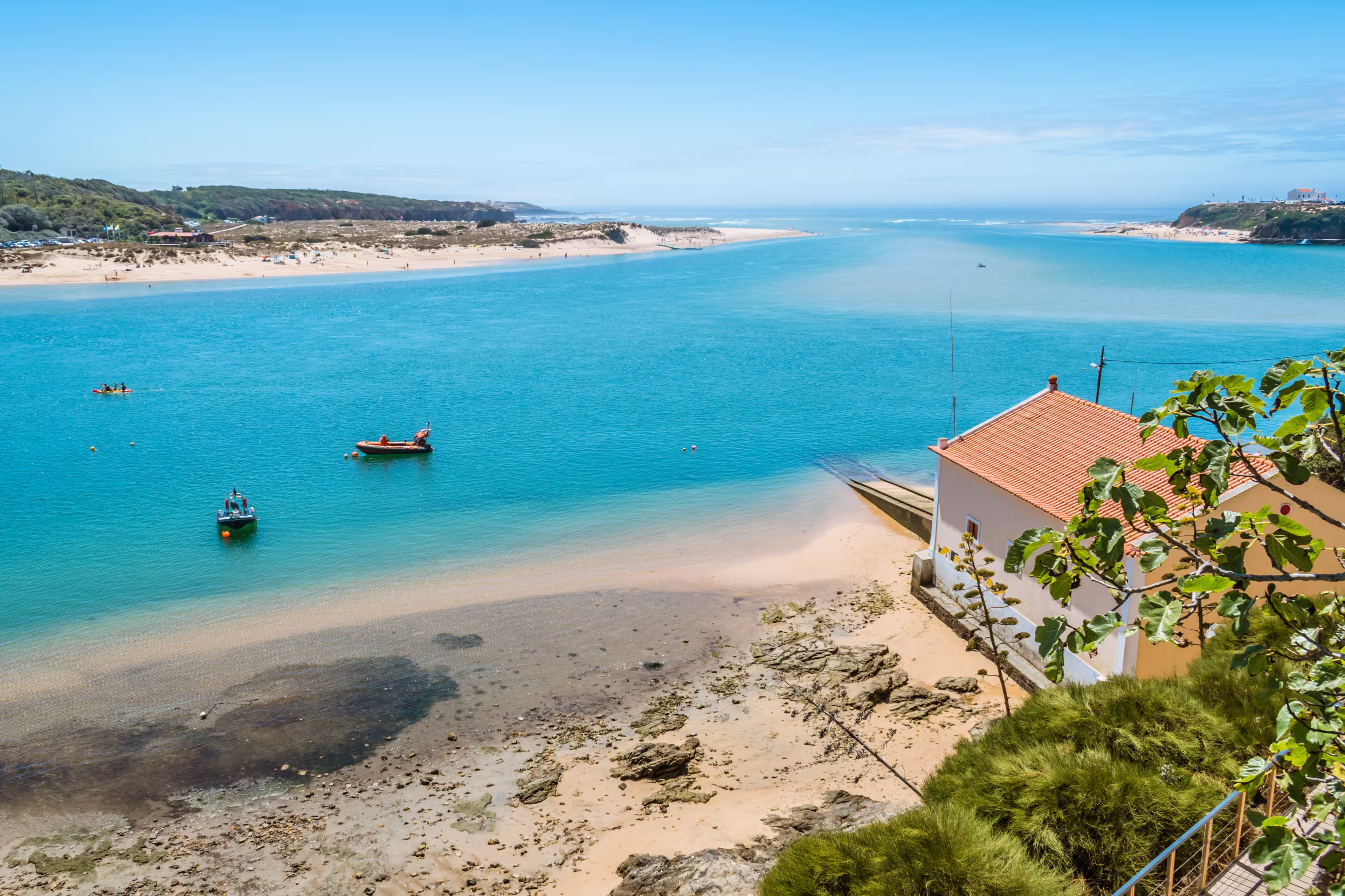 Breathtaking view of the mouth of the River Mira flowing into the Atlantic Ocean - Aquatic lifestyle sport in idyllic turquoise water, Vila Nova de Milfontes, Vicentine Coast Natural Park PORTUGAL