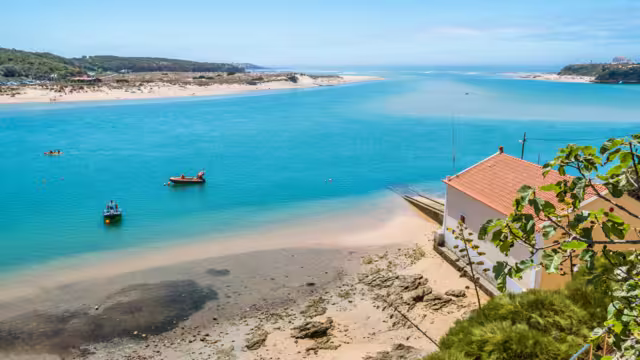 Breathtaking view of the mouth of the River Mira flowing into the Atlantic Ocean - Aquatic lifestyle sport in idyllic turquoise water, Vila Nova de Milfontes, Vicentine Coast Natural Park PORTUGAL